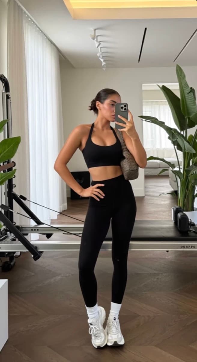 Olivia taking a mirror photo in a home workout studio